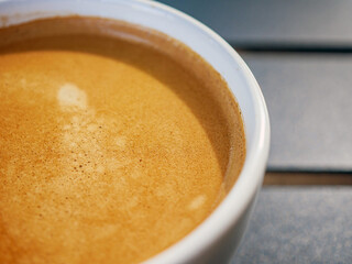 Coffee cream texture of fragrant coffee in a cup with delightful coffee colored bubbles with foam. macro coffee crema