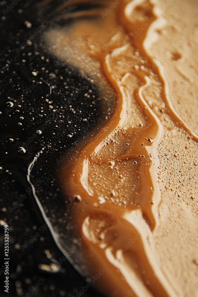 Poster close-up of dark liquid flowing on a surface, showing a dynamic mixture of black and brown, represen