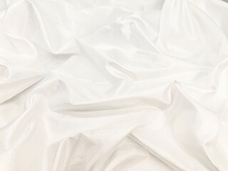  Soft white fabric background with gentle folds and subtle texture.