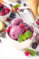 Homemade fruit and berry sorbet ice cream, portioned bowl with healthy fruit and berry yogurt gelato with fresh blueberry, raspberry, strawberry, blackberry, apples, kiwi on kitchen table