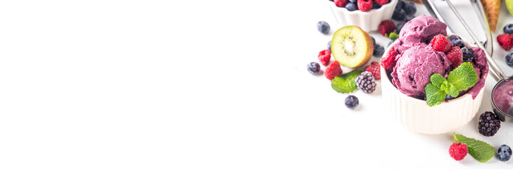 Homemade fruit and berry sorbet ice cream, portioned bowl with healthy fruit and berry yogurt gelato with fresh blueberry, raspberry, strawberry, blackberry, apples, kiwi on kitchen table