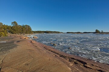 Rocky seashore and sea frozen on a cold winter day, Kopparnäs, Inkoo, Finland.