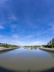 Fototapeta premium Water canal with blue sky and cloud at Gorontalo, Indonesia