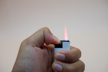 Hand holding an unlit matchstick against a neutral background