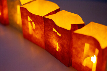 cardboard boxes illuminated with candles inside with letters cut out with the construction of the word happy birthday