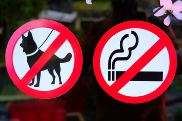 No dogs allowed sign and no smoking sign on a restaurant door.