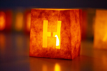 cardboard boxes illuminated with candles inside with letters cut out with the construction of the word happy birthday