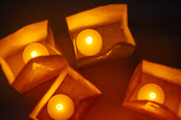 cardboard boxes illuminated with candles inside with letters cut out with the construction of the word happy birthday