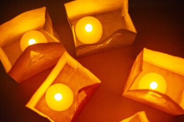 cardboard boxes illuminated with candles inside with letters cut out with the construction of the word happy birthday