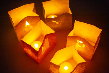 cardboard boxes illuminated with candles inside with letters cut out with the construction of the word happy birthday