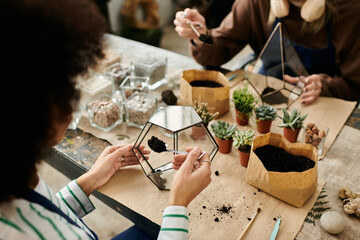 Friends craft colorful succulent terrariums at a nature inspired workshop