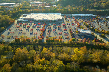 Aerial view grocery shopping mall and many colorful cars parked on parking lot with lines and...