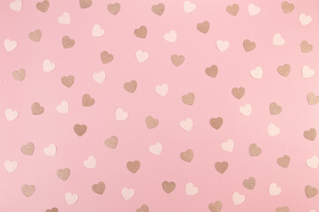 Top view of pink glitter hearts on pink background. Valentine's day, pink glitter hearts, love wallpaper. Flat lay, copy space.