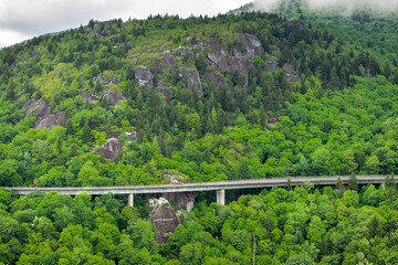 Blue Ridge Parkway road trip. Linn Cove Viaduct driving. Car exploration travel in summer forest on Appalachian mountain hills in North Carolina. Summertime landscape of beautiful nature