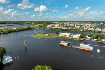 Farmland area flooded after hurricane rains. Underwater farm buildings under rainfall water in...