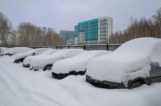 Cars in a street parking lot covered in snow