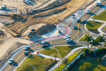 Industrial construction roadworks at roundabout intersection with moving cars in Venice, Florida....