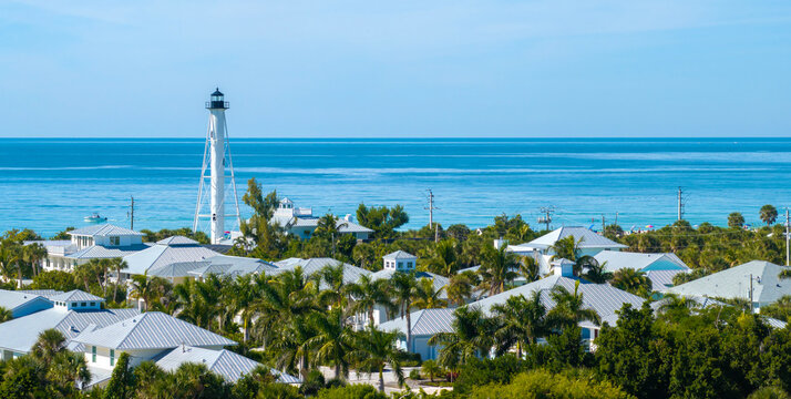 White lighthouse on sea shore for commercial vessels navigation at wealthy waterfront neighborhood in island small town Boca Grande on Gasparilla Island in southwest Florida, USA