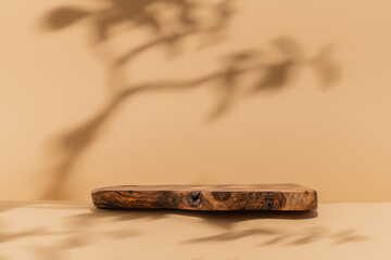 Table with rustic wood podium for food, cosmetic products, perfumes against beige background. Front view.	