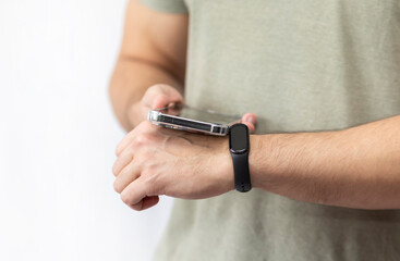 Fototapeta premium Close-up shot of man with smart band using smartphone isolated on white background