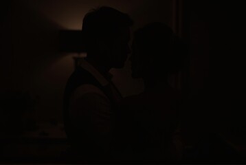 Silhouetted Couple Embracing in Darkness