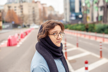 Fototapeta premium Young pretty woman walks on street across the road.