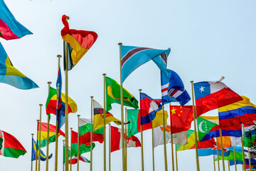 Many poles with flags of countries and all nations members of UN (United Nations) floating in the wind, international organisation, peace symbol