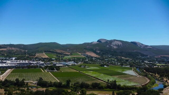 Camera panning right to left across Paarl Town South Africa with the iconic Paarl rock behind the town 4K Aerial Video.