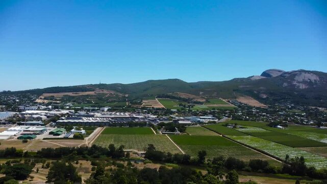Camera panning left to right across Paarl Town South Africa with the iconic Paarl rock behind the town 4K Aerial Video