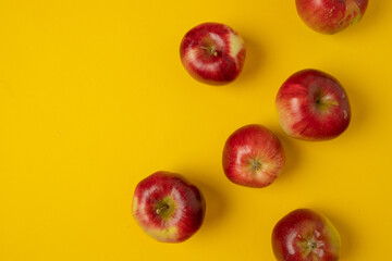 Flat lay composition with many red apples on yellow background. Space for text. High quality photo