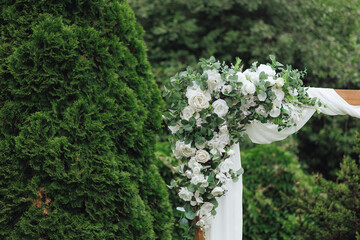 Wedding ceremony in nature with an arch decorated with white flowers