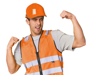 Young Hispanic worker in safety gear raising fist after a victory, winner concept.