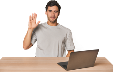 Hispanic young man working on laptop smiling cheerful showing number five with fingers.