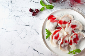 Hot dessert. Cherry dumplings with sweet sauce. Vegetarian food.