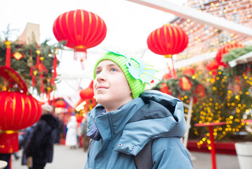 
Portrait of a European teenager boy on Chinese New Year. Child at a festival decorated for the...