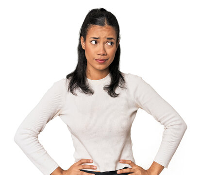 Young Filipina woman confused, feels doubtful and unsure.