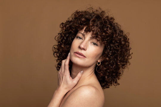 Seductive woman posing against brown background