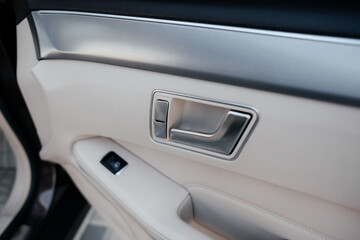 Modern interior of a business class car, white perforated leather, aluminum, black varnish, leather steering wheel.