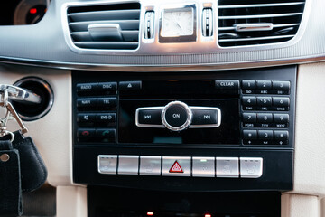 Modern interior of a business class car, white perforated leather, aluminum, black varnish, leather steering wheel.