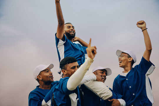 Joyful baseball team celebrating victory with teamwork and unity under a clear sky