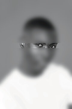 Blurred portrait highlighting the expressive eyes of a young man conveying a sense of mystery and focus