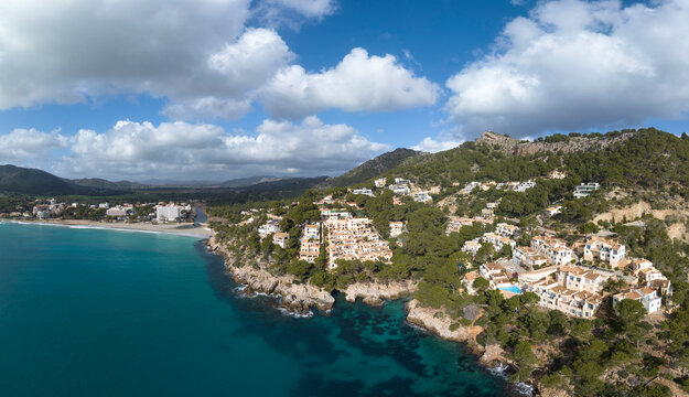 Aerial view of the coastline in Capdepera, Mallorca, featuring Cuevas de Arta and Platja de Canyamel under a cloudy sky.
