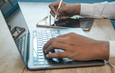 teenager man sitting on the chair using stylus pen and digital tablet homework on laptop, online...
