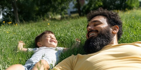 Father and son share joyful laughter lying on lush green grass, capturing a tender moment of bonding and happiness amidst nature.