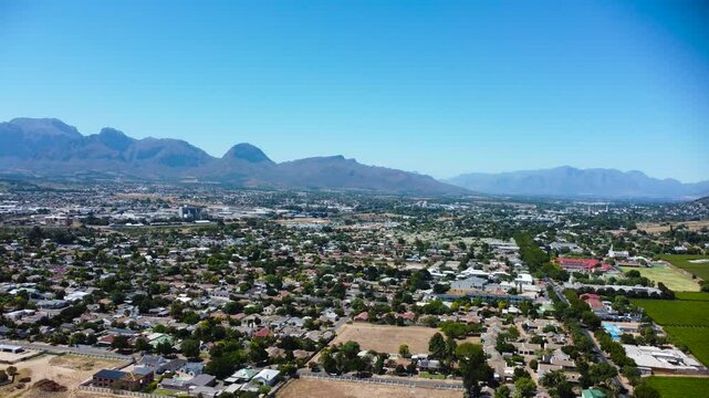 Camera slowly moving away from Paarl Town South Africa with the iconic Paarl rock and the Mountain range behind the town 4K Aerial Video
