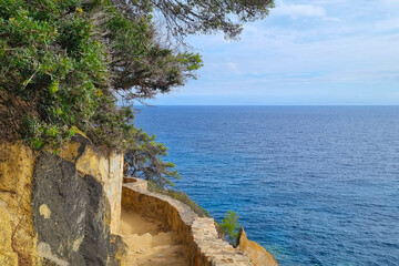 Fototapeta premium Coastal Cliff Path Overlooking the Mediterranean Sea on a Tranquil Summer Day