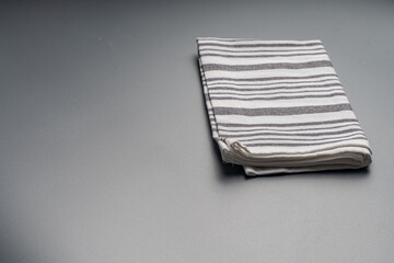 The towel is light gray with white stripes on a gray background. Space for text.