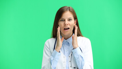 Female doctor, close-up, on a green background, is surprised