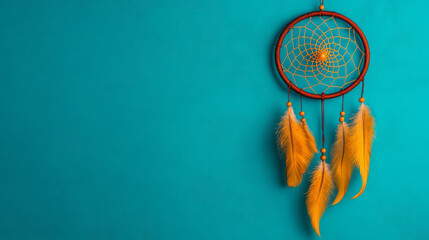 An elegant dreamcatcher with intricate webbing set against a textured teal wall, feathers lightly