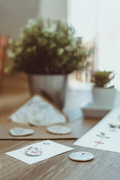 Assorted houseplants, ceramic ornaments and stationery on a wooden table by a window